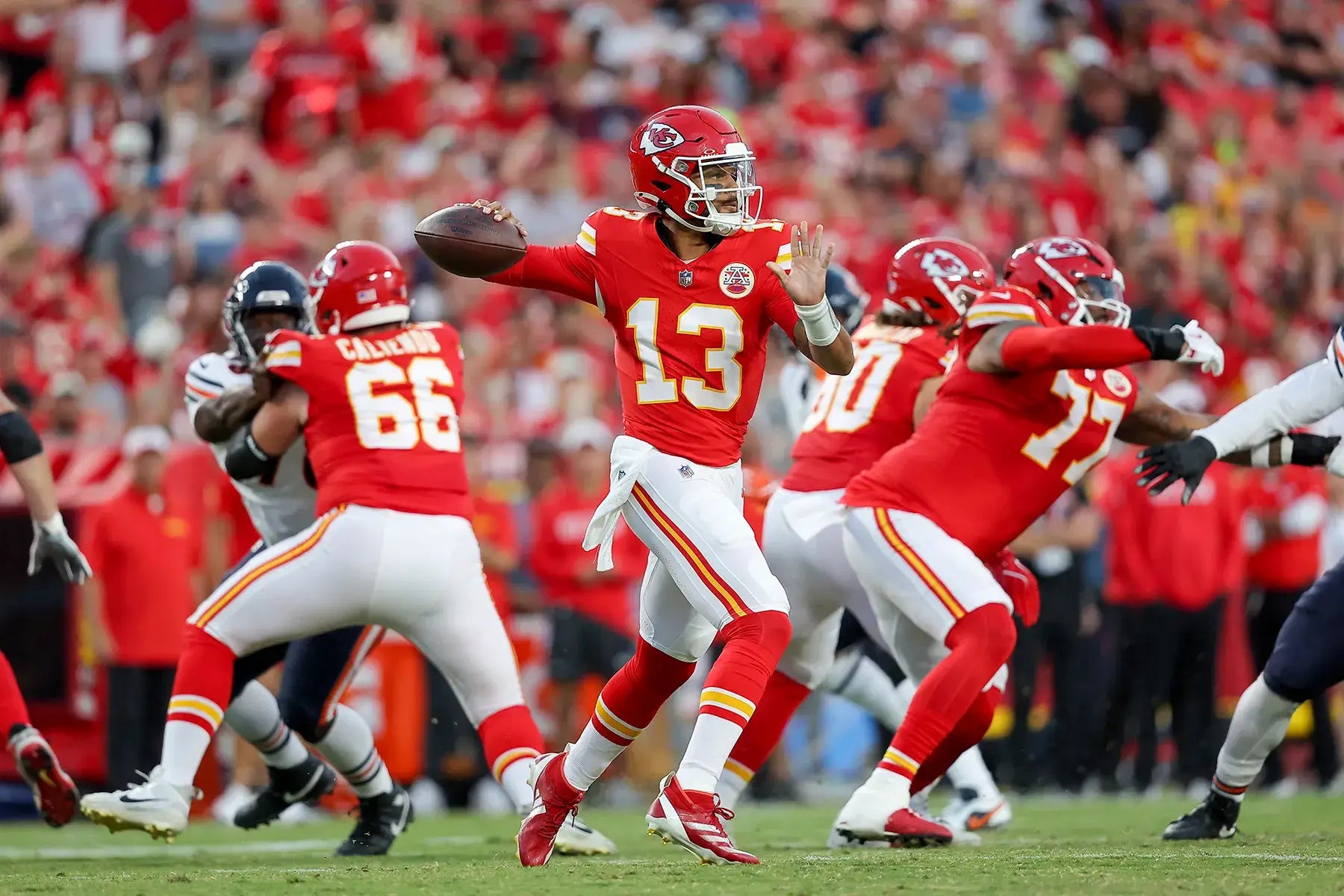 American football player in red uniform throwing the ball during a game.